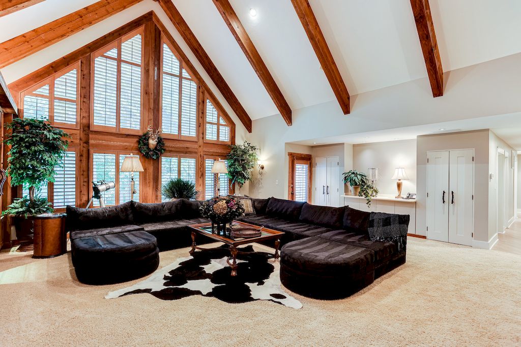 This is an authentic country house. They abandoned the idea of high-rise houses in favor of building the roof house on a large plot of land. The wooden beams and door frames complement the typical nature-inspired artwork perfectly. Furthermore, the black long couch with two lounge couches on either side is a relaxing retreat. The black and white carpet completes the look.