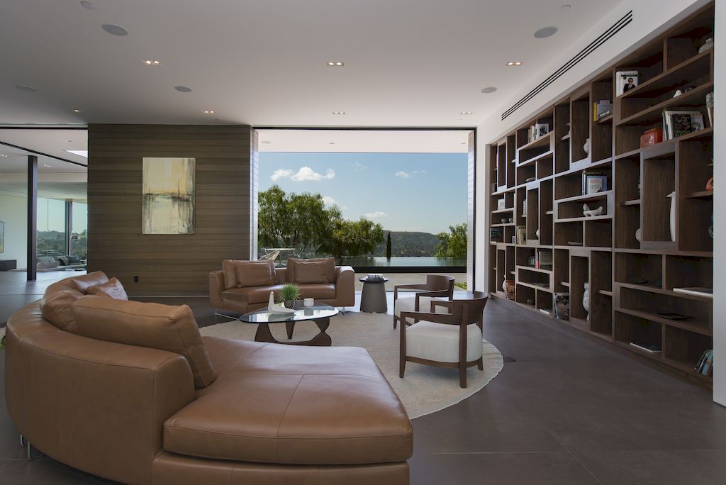 With the idea of a gentleman's club in mind, this library area/living room was designed as a relaxing place to read a book, make calls, and catch up on emails. The room feels both beautiful and cozy thanks to the dark color scheme, and the deep plum velvet only heightens the opulence.