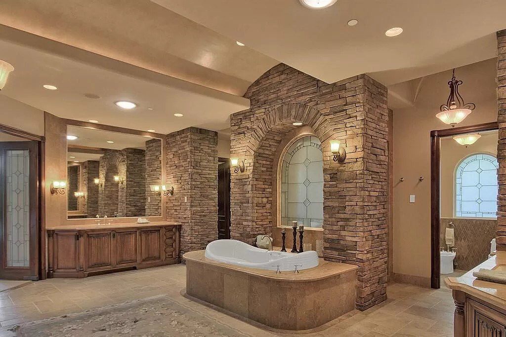Sometimes, just with the right architecture and appropriate building materials, you can create a rustic yet luxurious bathroom space. A bathtub with a partition wall built entirely from bricks serves as a focal point and blends well with the overall architecture.