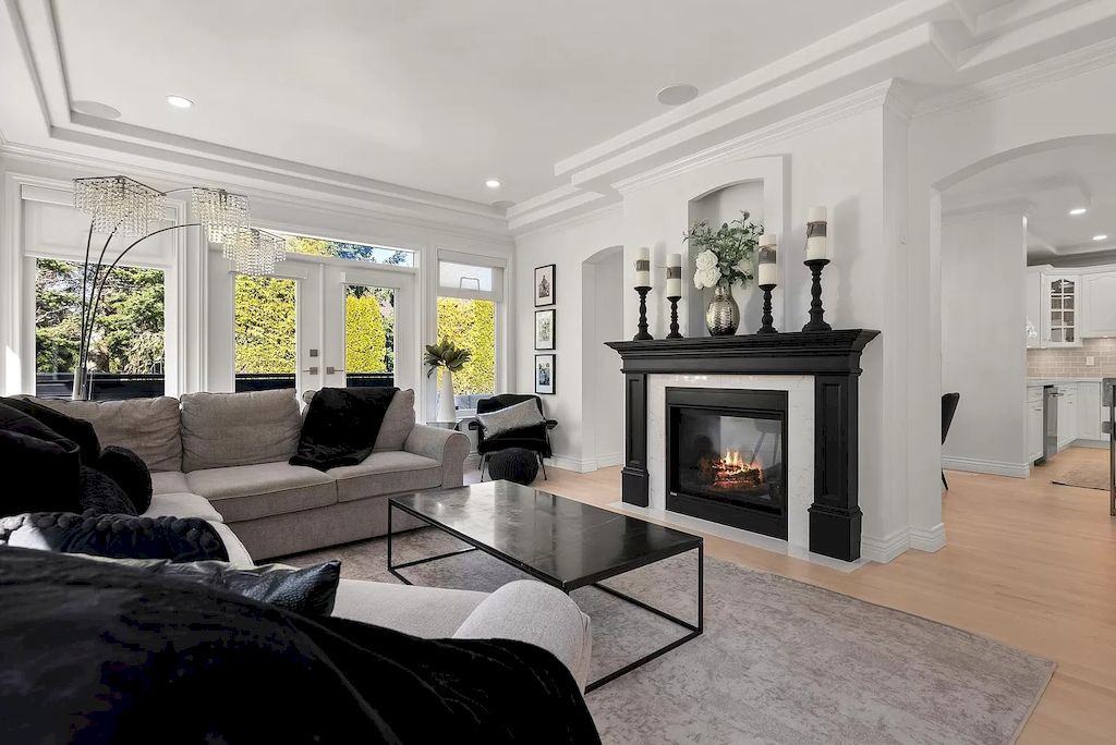 The traditional color combination of black and white is suitable for use in any space. This living room acknowledges this by maintaining a largely white background and incorporating minor amounts of neutral in the surrounding space. In particular, the fireplace offers a dramatic contrast between the black mantle and the white shiplap wall behind it.