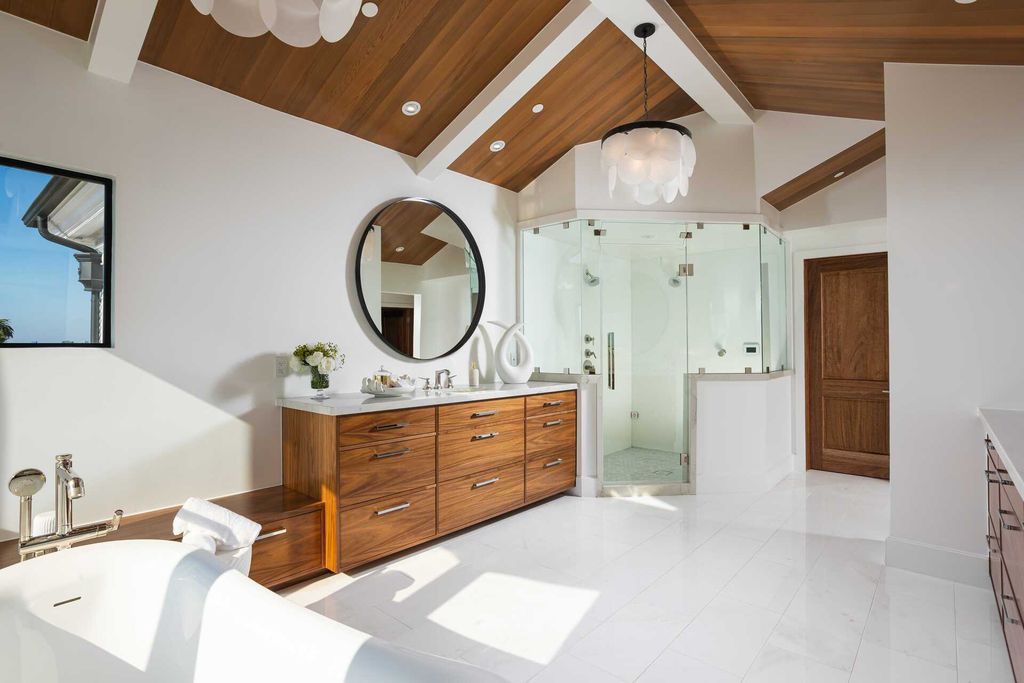 Add a touch of luxury to a rustic bathroom by incorporating elegant ceiling light fixtures. The interplay between classic architecture and youthful, modern furnishings is a perfect way to complete the look and add liveliness to a rustic bathroom in a luxury estate.