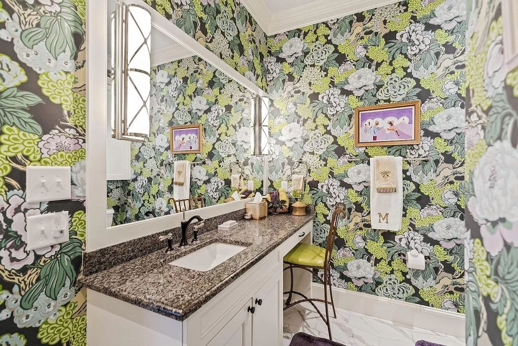 A wallpapered accent wall may liven up a powder room. This floral pattern adds a splash of color to the modest bathroom. For the best protection, use vinyl-coated wallpaper that can tolerate dampness and materials branded "scrubbable."