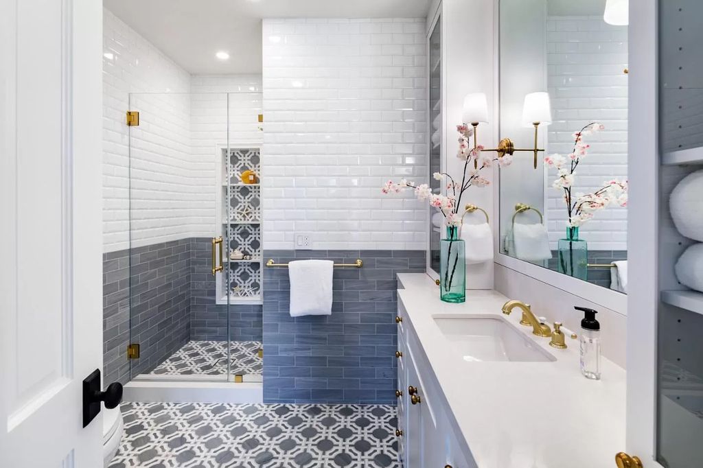 Smartly zoning your bathroom space with the creation of a room within a room rule. It's like you're creating a luxurious, spa like layout in your own home. In this unique bathroom, sleek glass and metal panels have been used for the entryway. The overall design makes for a gorgeous bathroom space, with a modern, artistic feel.