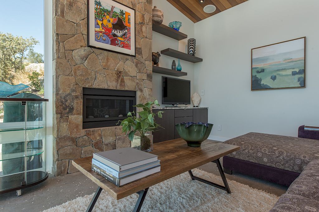 Although a modern home has wonderful straight walls and clean lines, it frequently lacks the personality of a more ancient building. On this crimson, antique wall, you can hang a dramatic photo collage. The artwork frames the log burner well and gives the view from the armchairs a really intriguing feel.