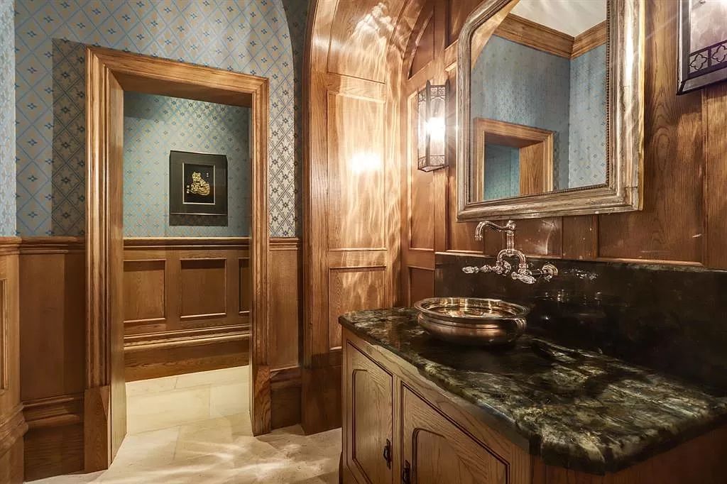 This rustic bathroom boasts a cozy green wallpaper that creates a warm and inviting atmosphere. Wooden materials are used throughout the space, adding to its rustic charm and creating a natural aesthetic. Despite its small size, the bathroom feels spacious and comfortable, thanks to the clever use of materials and the addition of a beautiful copper wash basin, which adds an elegant touch to the overall design.