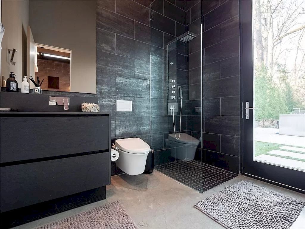 Gray bathroom ideas can be toughened up by adding industrial elements to the design. To achieve this look, consider using gray concrete tiles on the walls or floors, or adding a concrete countertop to the vanity. Exposed pipes and metal fixtures can add an edgy and industrial feel to the space. You can also incorporate black or dark gray metal accents, such as a metal-framed mirror or shelving, to further enhance the look. .