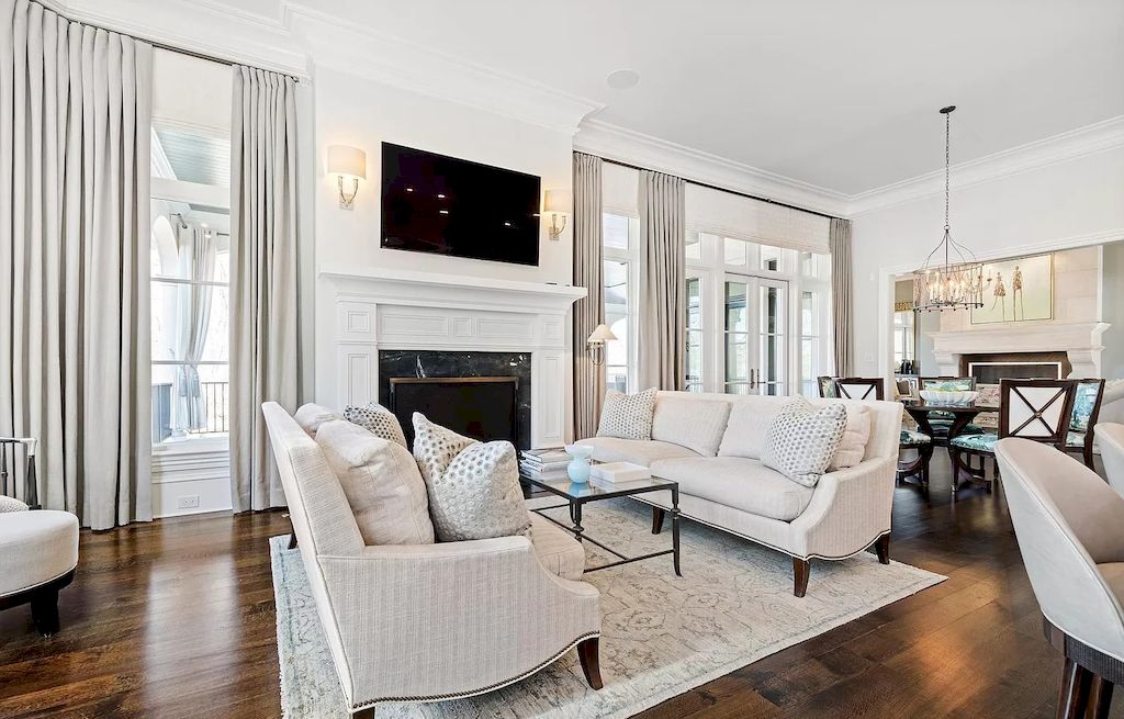 This room has a feeling of simple cleanliness because of its all-white decor, including the ceiling. The way the various materials used for the walls and the ceiling beams' matching hues interact with the room's all-white furnishings is intriguing.