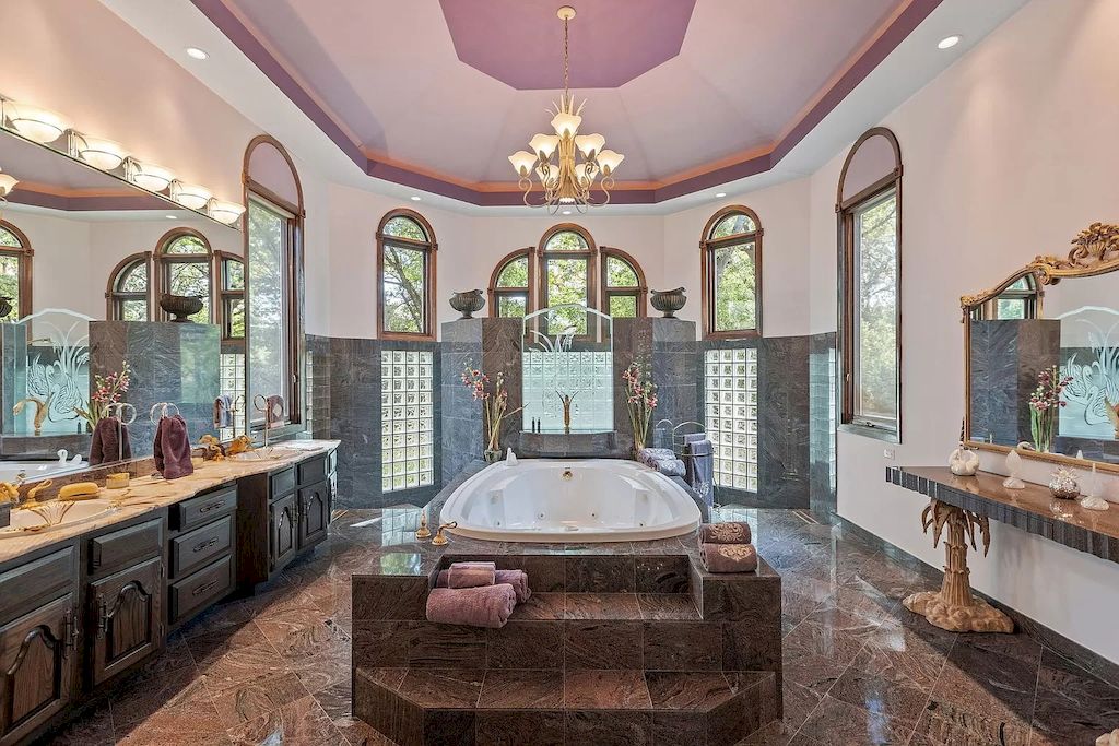 A place may be drastically transformed by a vibrant color scheme, as demonstrated in this bathroom design where the vanity was painted in a vivacious pink hue. A simple approach to add texture and make the pink color stand out even more is with a gold decorative mirror.