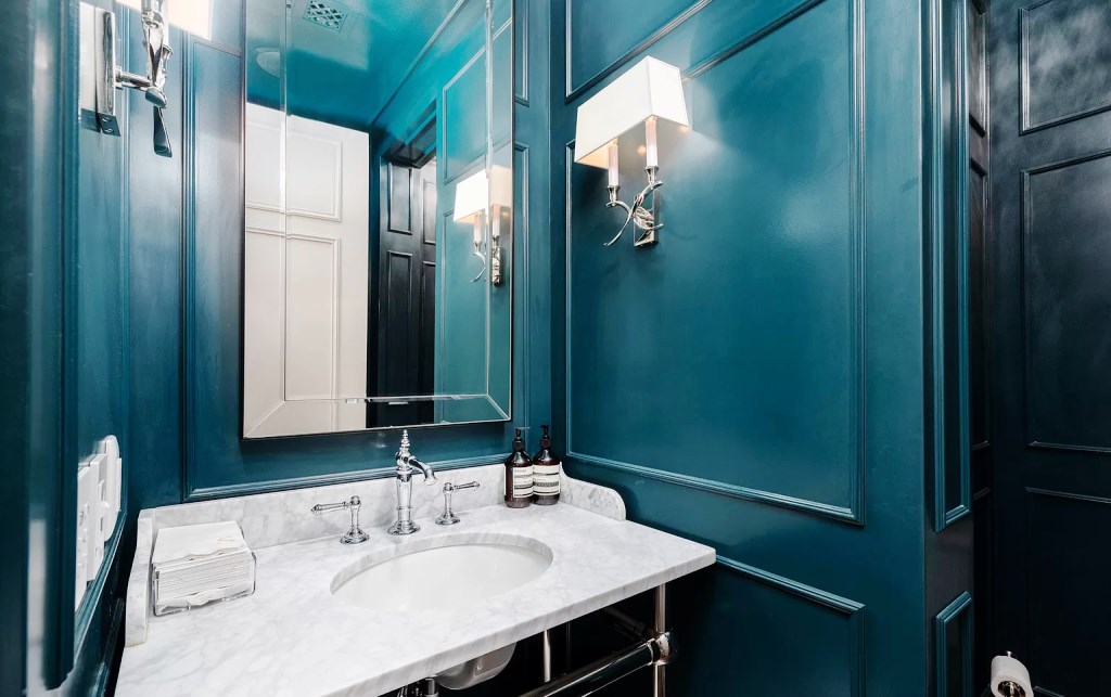 One of the Arizona designs makes this bathroom modern and close to contemporary. The ceramic tile hand basin shines and pops against the green room backdrop. The large mirror is another important factor in increasing the amount of light in the room.