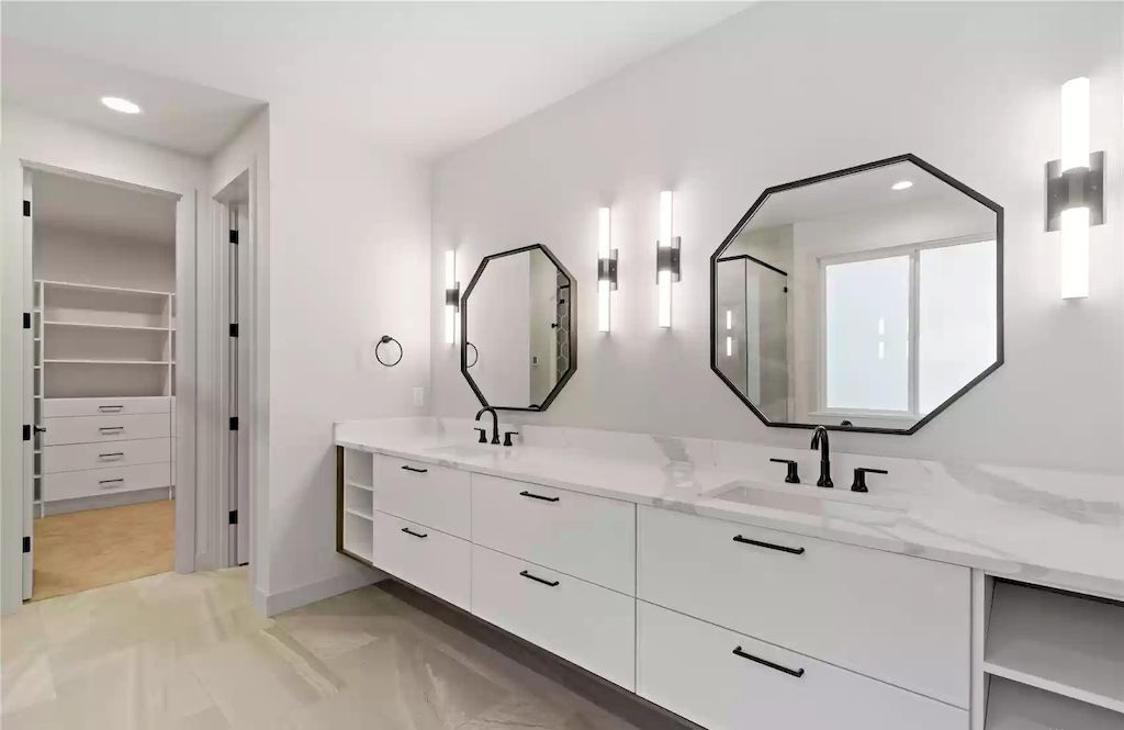 Bathrooms are generally the smallest rooms in the house, so they must make the most use of the limited space. As a result, every corner and cranny in your bathroom design is important. In this case, a little corner of the bathroom has been used to accommodate a fitted vanity with a marble countertop and upstand. It's been combined with bold wall lighting and a mirror to create a little area that's just as practical as larger bathroom vanity ideas.