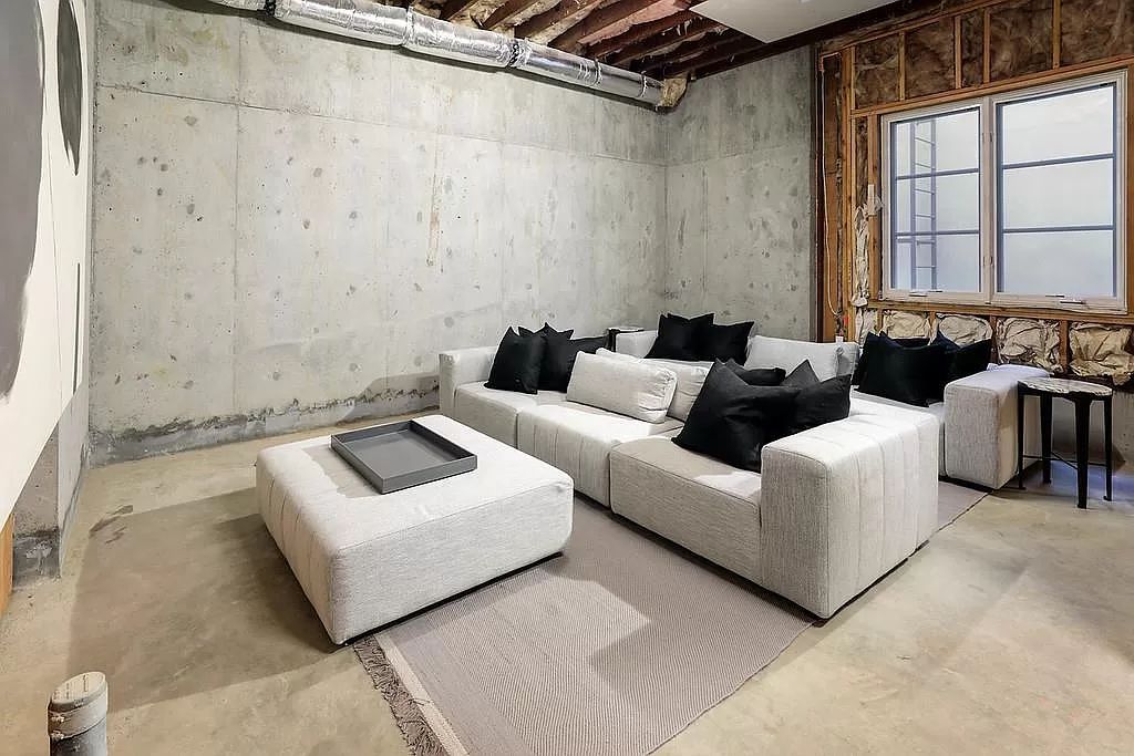 Use neutral colors like grey and white for large pieces of design to keep a room simple. Colors can be mixed in a modern, classic, or even industrial style, depending on your preferences. In contrast to the comfort and lightness of the pure white sofa, clever dark grey dots on the cement wall provide strength. Only the wooden door frames are nature-inspired elements in the living room, adding a sense of lightness.