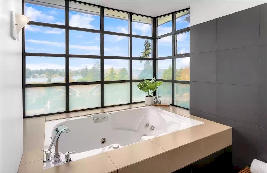 The light, gray color scheme gives this bathroom a revitalizing vibe without becoming overpowering. Small personal touches like the framed poster and potted plants give the bathroom a more relaxed atmosphere while still complementing its style.