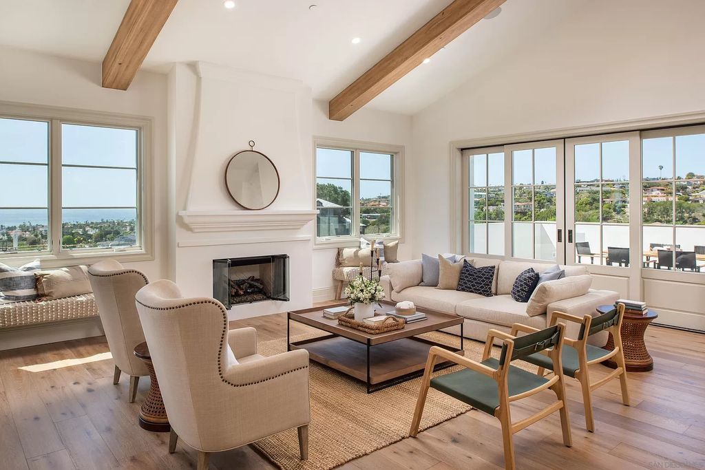 A neutral palette comes alive when it consists of a combination of light to dark hues in mix of textures. From top to bottom, high ceiling living room with natural wooden beam sitting atop wood side tables, pillows made from vintage textiles decorate a woven fabric sofa, and a caramel brown carpet in the same color as the floor tiles.