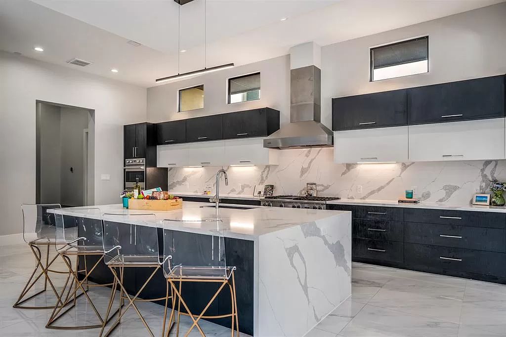 You also cannot overlook the combination of two classic colors, black and white - a prime example of the effectiveness of applying color contrast. This black-and-white kitchen cabinet in the above luxury idea approach not only adds depth and dimension but also allows for flexibility in incorporating various textures and materials, making the kitchen a truly inviting and stylish focal point of the home.