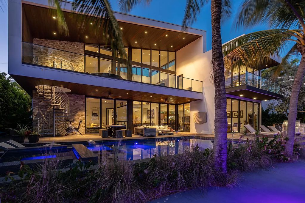 The Home in Boca Raton is a waterfront contemporary estate has a dramatic two story great room with extensive glass views the open pool, patio and canal now available for sale. This home located at 830 NE 71st St, Boca Raton, Florida
