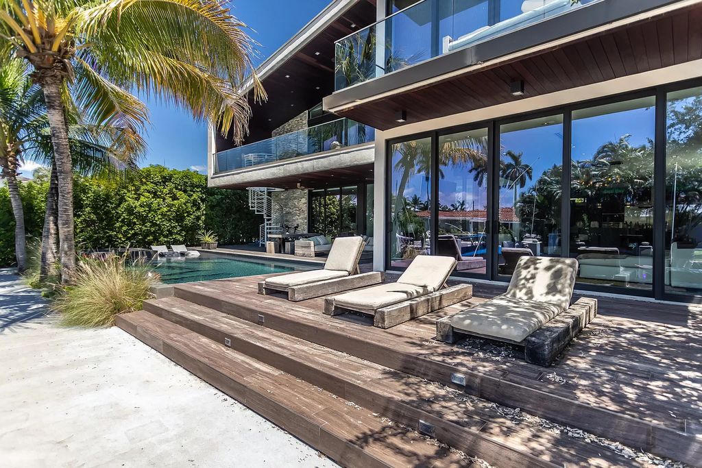 The Home in Boca Raton is a waterfront contemporary estate has a dramatic two story great room with extensive glass views the open pool, patio and canal now available for sale. This home located at 830 NE 71st St, Boca Raton, Florida