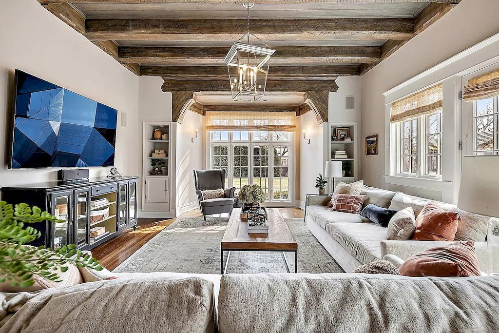 If you are lucky enough to have an arched ceiling or original beam, leave it original and consider adding a few highlights to your living room. Nothing is more suitable for a traditional living room with exposed beams than floor-to-ceiling windows and white hues interior. Exposed beam often appears in traditional living rooms with rustic or farmhouse style because of their closeness and minimalism. You can also decorate with an underneath rug with classic patterns or vintage curtains to level up your Traditional Living Room Ideas.