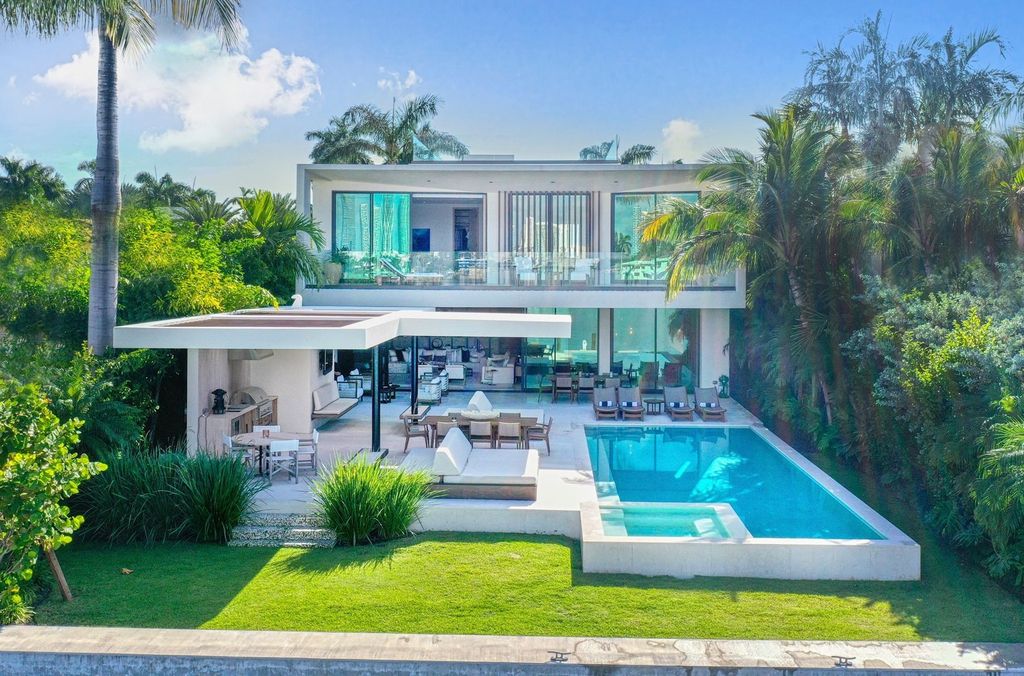 The Home in Miami Beach is a magnificent modern estate fully furnished with only the best  with spectacular, direct, downtown wide-bay views now available for sale. This home located at 100 W San Marino Dr, Miami Beach