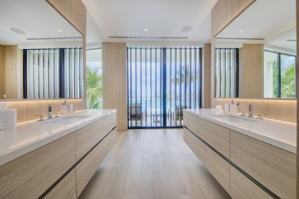 The Home in Miami Beach is a magnificent modern estate fully furnished with only the best  with spectacular, direct, downtown wide-bay views now available for sale. This home located at 100 W San Marino Dr, Miami Beach