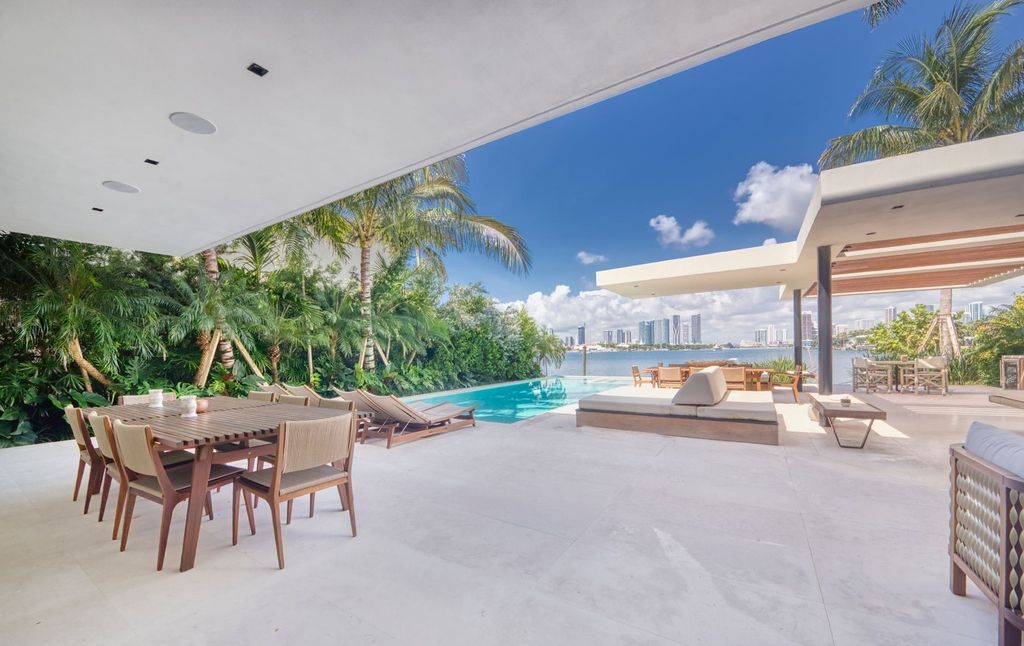 The Home in Miami Beach is a magnificent modern estate fully furnished with only the best  with spectacular, direct, downtown wide-bay views now available for sale. This home located at 100 W San Marino Dr, Miami Beach