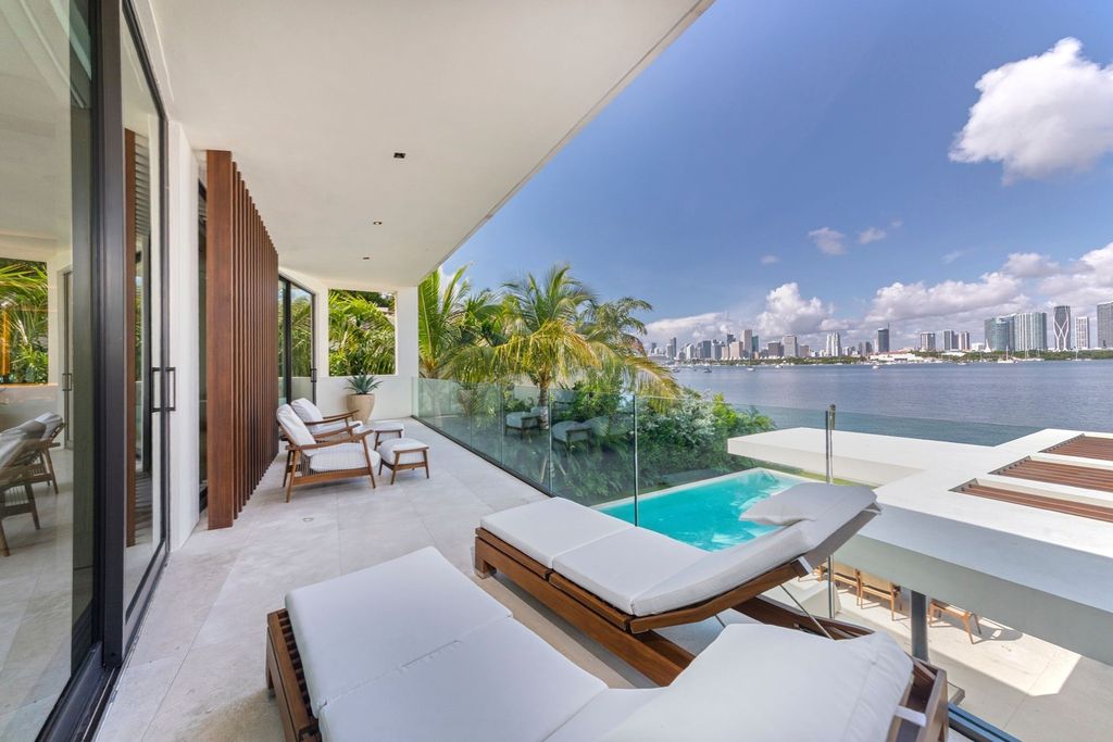 The Home in Miami Beach is a magnificent modern estate fully furnished with only the best  with spectacular, direct, downtown wide-bay views now available for sale. This home located at 100 W San Marino Dr, Miami Beach