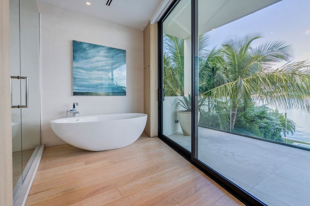 The Home in Miami Beach is a magnificent modern estate fully furnished with only the best  with spectacular, direct, downtown wide-bay views now available for sale. This home located at 100 W San Marino Dr, Miami Beach