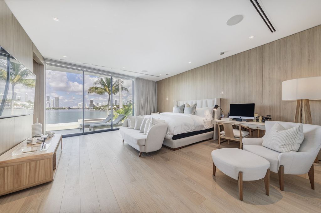 The Home in Miami Beach is a magnificent modern estate fully furnished with only the best  with spectacular, direct, downtown wide-bay views now available for sale. This home located at 100 W San Marino Dr, Miami Beach