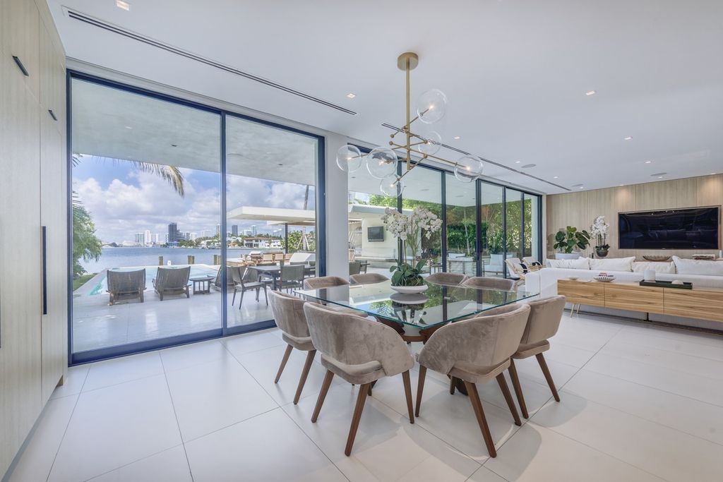 The Home in Miami Beach is a magnificent modern estate fully furnished with only the best  with spectacular, direct, downtown wide-bay views now available for sale. This home located at 100 W San Marino Dr, Miami Beach