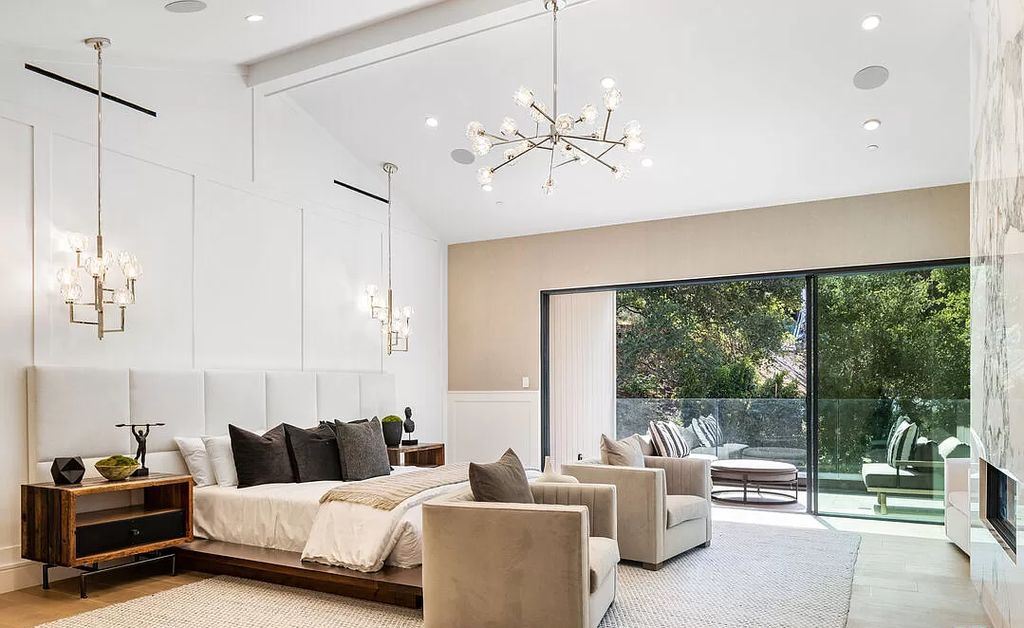 The bedroom is light and airy, with a king-sized bed and soft materials. A headboard that extends beyond the size of the bed is a trick for increasing the size of the bed. When the nightstand is mounted directly onto the headboard, it functions as a unit. Ambient lighting illuminates the entire master bedroom.