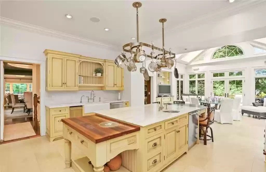 In order to create extra space for pots, pans and other utensils in the kitchen while also having a focal point, consider installing a sturdy ceiling rack with hooks. This kitchen design serves as a unique display for your family's favorite cooking utensils. For making the hanging rack even more dazzling, you can integrate a recessed lighting system around it. The metallic pots and pans will shine and become more eye catching than ever thanks to the reflected light. 