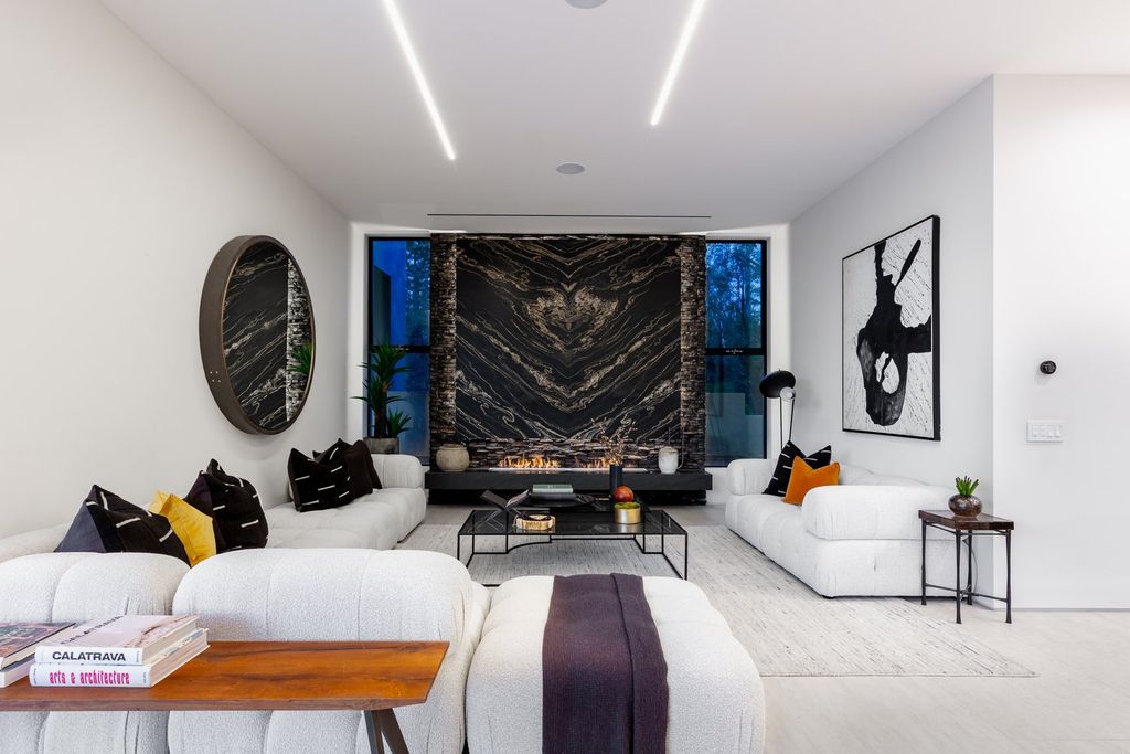 This living room is connected to other areas and is situated in a corner. As a result, the designer chose the most elegant colors. The clean white sofa set has produced a gentle and soft overall effect. The contrast of black walls with white veins is both appealing and luxurious. A great decor, such as this one, is impossible to overlook.