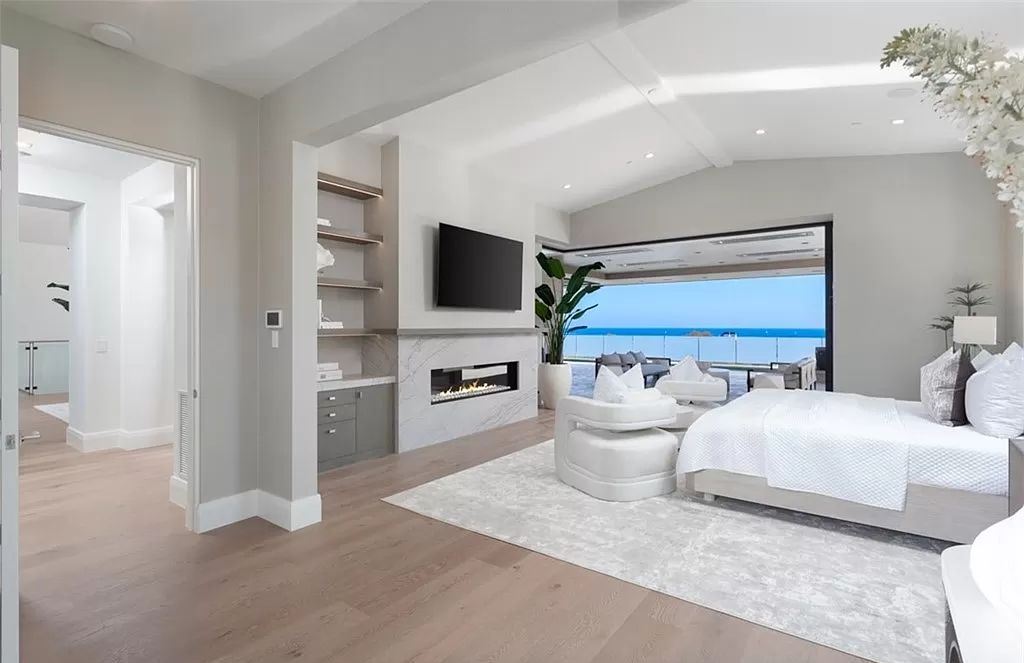 This bedroom's gentle simplicity complements the black and white color scheme well. Additionally, there is some additional warmth and contrast provided by the structural wooden beam.