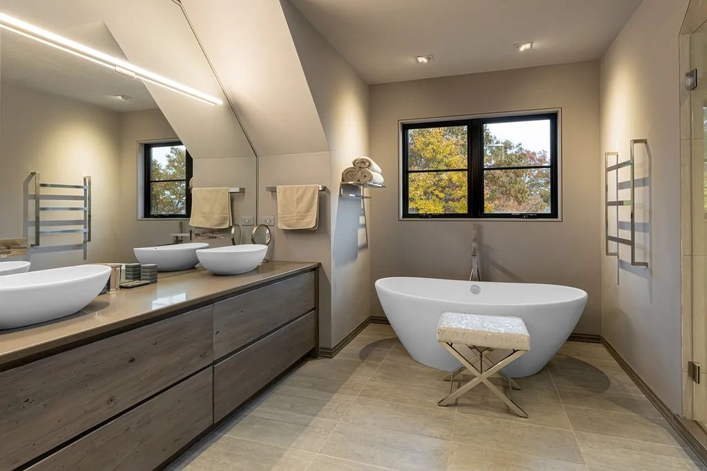 The neutral bathroom becomes classic and timeless with a unique design in the vanity area. The simple and minimalist hanging bars also adhere to the homeowner's desired design style.