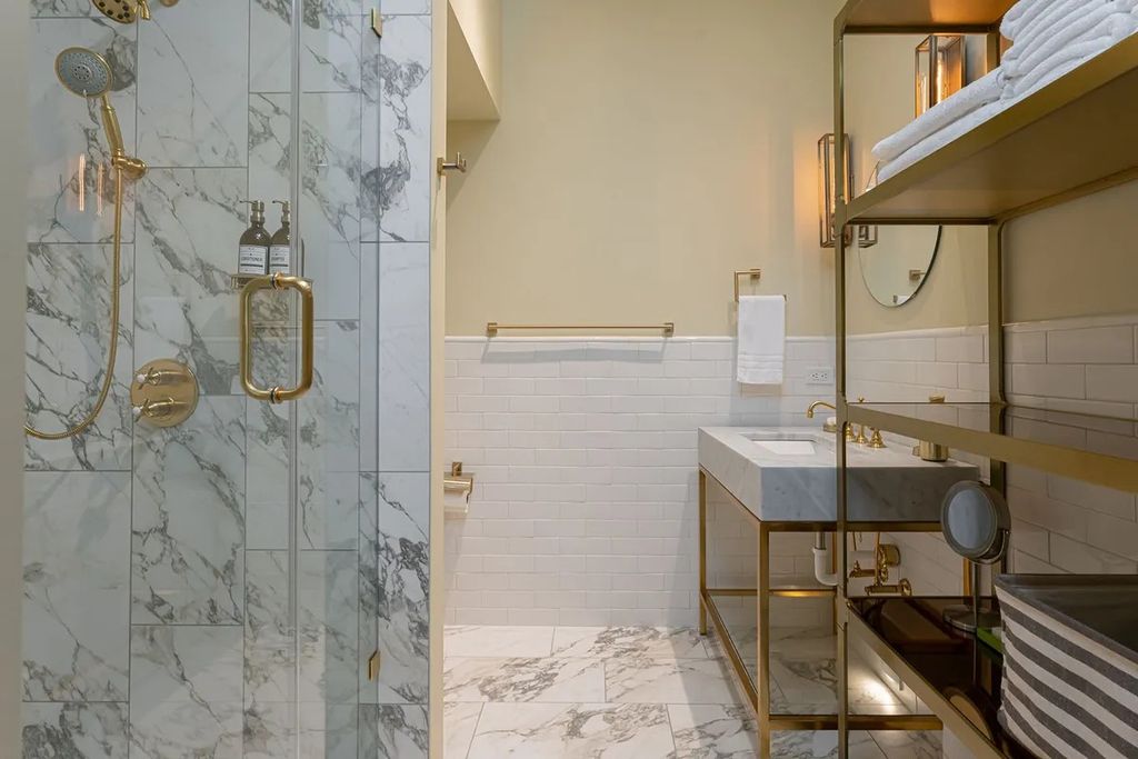 Your bathroom is the one area in your home that most needs some luxury. If you want an attractive spa-like finish, we advise adhering to a neutral color scheme and employing wall-mounted furniture to preserve floor space. This helps prevent the area from feeling boxy by avoiding the use of distinct colors to divide it out. It's these brushed gold fixtures that truly make this bathroom shine, so don't be afraid to add a little glitz.