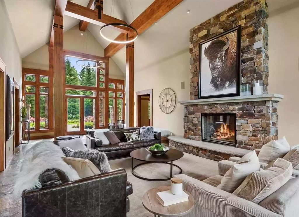 White coffered ceiling and walls effortlessly open this vintage living room idea. A huge picture, classic natural stone fireplace, fur blanket, and pillow add more vintage flavor to this stunning space. The dark-toned of sofa and distinctive table reinsure the living room with unmatched warmth.