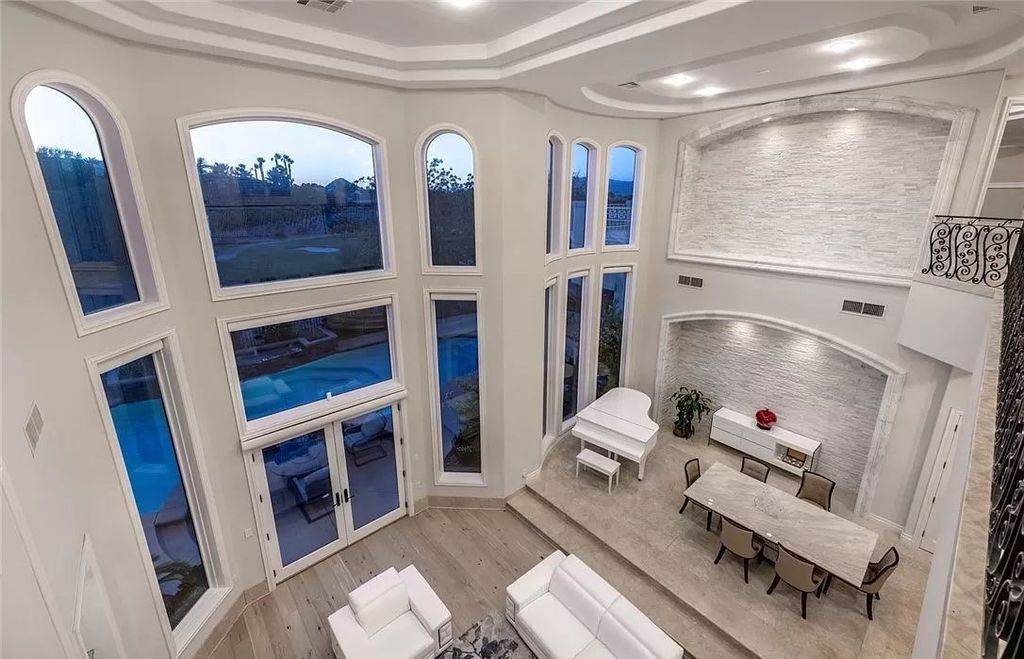 The Home in Las Vegas is a grand residence greeted by floor to ceiling windows showcasing the sky, mountains and golf course setting on a sought after guard gated golf communities now available for sale. This home located at 1425 Iron Hills Ln, Las Vegas, Nevada