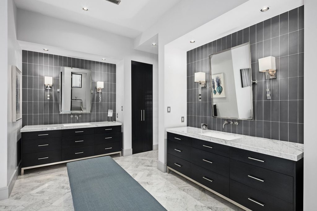 The focal point of this contemporary bathroom is a striking black and white accent wall. How much can be accomplished in a tiny space is demonstrated by this compact bathroom idea. From the light to the rug to the beautiful artwork on the shelf above the toilet, every little thing is meticulously handmade.