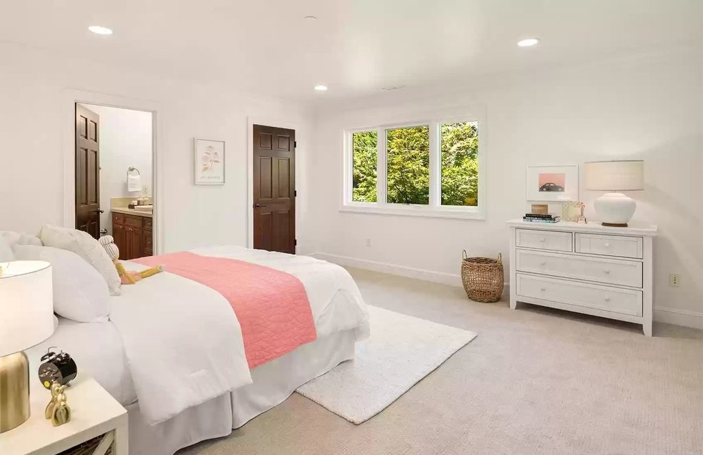 This neutral and contemporary bedroom is given a charming and playful feel by bedspreads decorated with pale pink sheets and artwork.