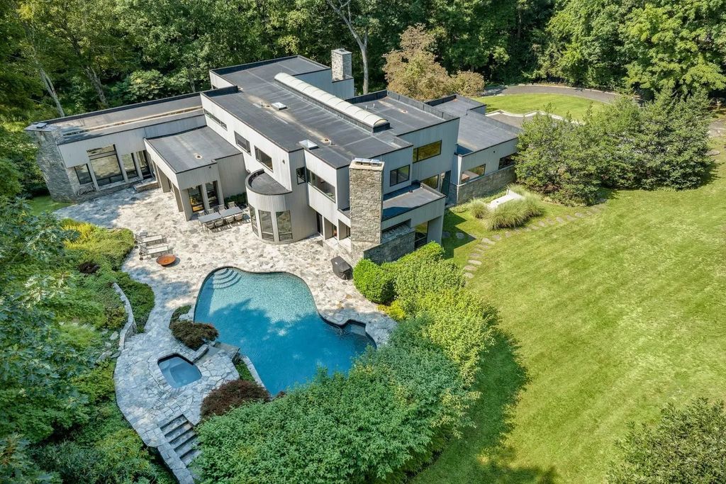 The House in Greenwich features backyard patio with pool and spa, barbecue and outdoor firepit, now available for sale. This home located at 49 Vineyard Ln, Greenwich, Connecticut