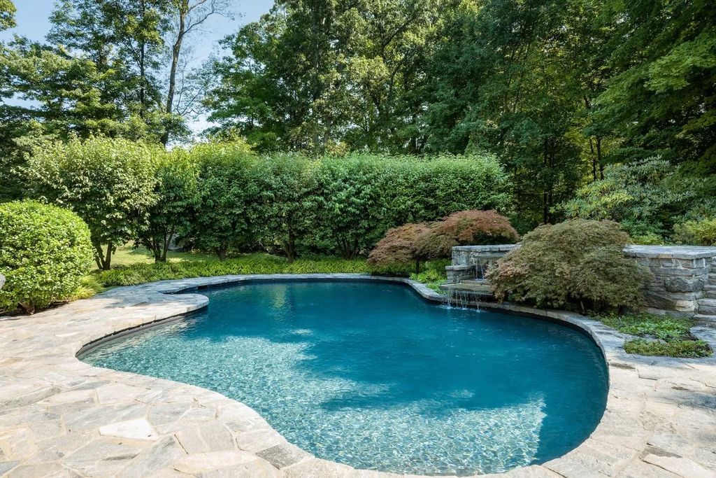 The House in Greenwich features backyard patio with pool and spa, barbecue and outdoor firepit, now available for sale. This home located at 49 Vineyard Ln, Greenwich, Connecticut