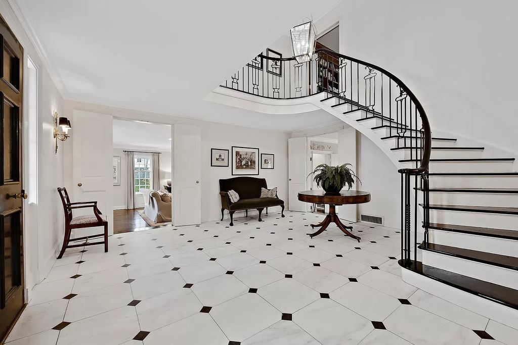 The House in Winnetka offers inviting two-story foyer with curved staircase and marble floors, now available for sale. This home located at 62 Woodley Rd, Winnetka, Illinois