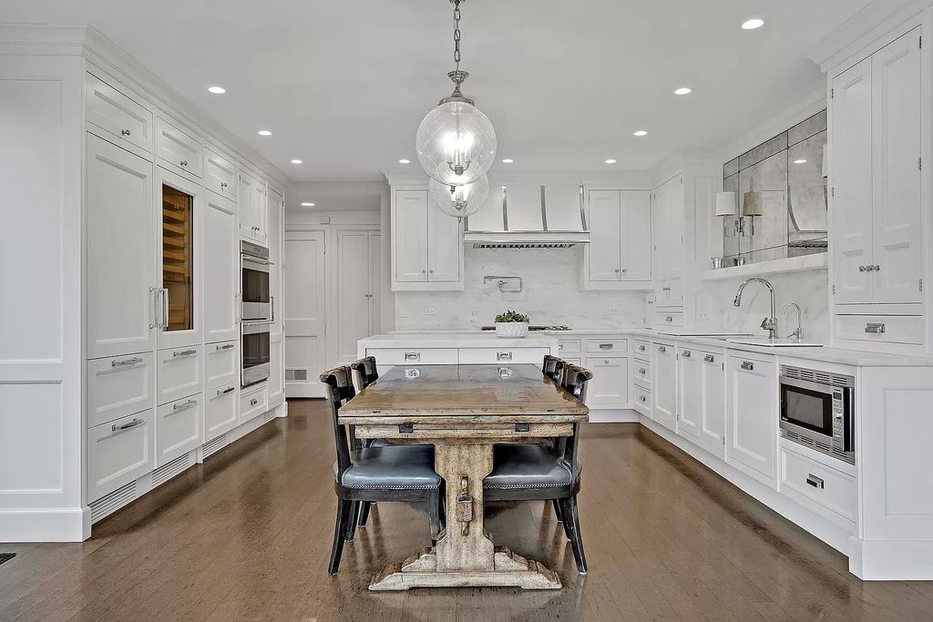 The House in Winnetka offers inviting two-story foyer with curved staircase and marble floors, now available for sale. This home located at 62 Woodley Rd, Winnetka, Illinois