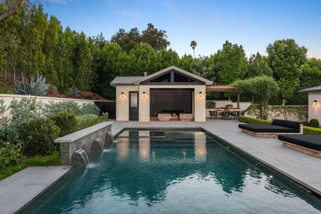 The Farmhouse in Encino, a gated privacy home enchants with tall hedges, rolling lawns and an exquisite exterior offering breathtaking 9,380 square foot floorplan across two levels is now available for sale. This home located at 16766 Bosque Dr, Encino, California