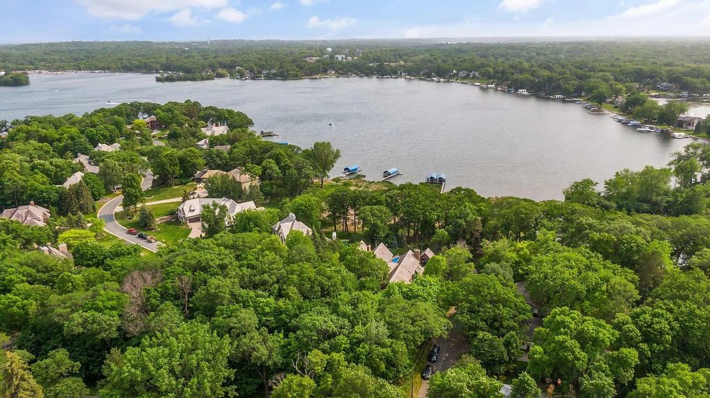 The Home in Minnesota includes ultimate outdoor living spaces with a pool, hot tub room, sauna, deck, screened porch, and a dock, now available for sale. This home located at 10 Gideons Point Rd, Tonka Bay, Minnesota