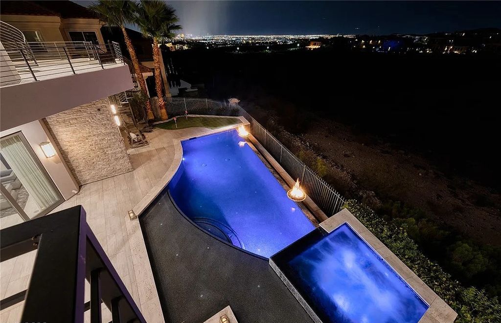 The Villa in Henderson, a custom modern contemporary architecture by Richard Luke offers elegant walk-on-water entrance, movie theater, glass wine cellar, game room, office, elevator, pocket doors, linear fireplaces, and more is now available for sale. This home located at 2656 Mirabella St, Henderson, Nevada