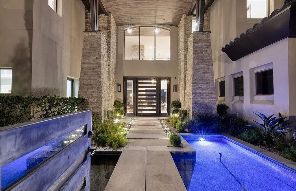 The Villa in Henderson, a custom modern contemporary architecture by Richard Luke offers elegant walk-on-water entrance, movie theater, glass wine cellar, game room, office, elevator, pocket doors, linear fireplaces, and more is now available for sale. This home located at 2656 Mirabella St, Henderson, Nevada