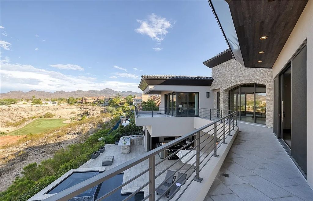 The Villa in Henderson, a custom modern contemporary architecture by Richard Luke offers elegant walk-on-water entrance, movie theater, glass wine cellar, game room, office, elevator, pocket doors, linear fireplaces, and more is now available for sale. This home located at 2656 Mirabella St, Henderson, Nevada