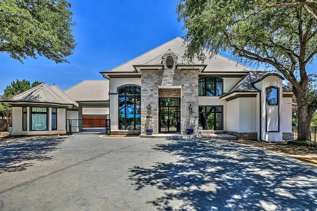 5801 Cypress Point Dr, Fort Worth, Texas is stunning remodeled estate in guarded and gated Mira Vista community on a cul-de-sac lot overlooking the 7th tee box, green and lake.