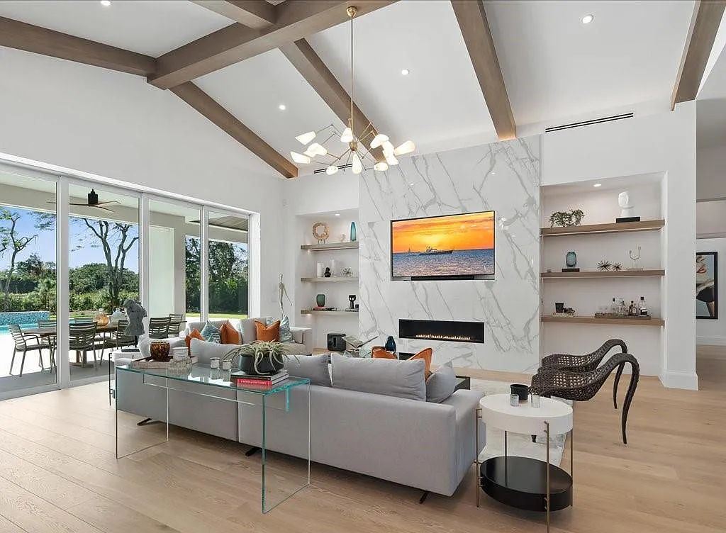 62 Ridge Drive, Naples, Florida is a captivating and stylish home with an expansive living room, an ultimate outdoor area, an office, a laundry room, and an attached 3-car garage and more.