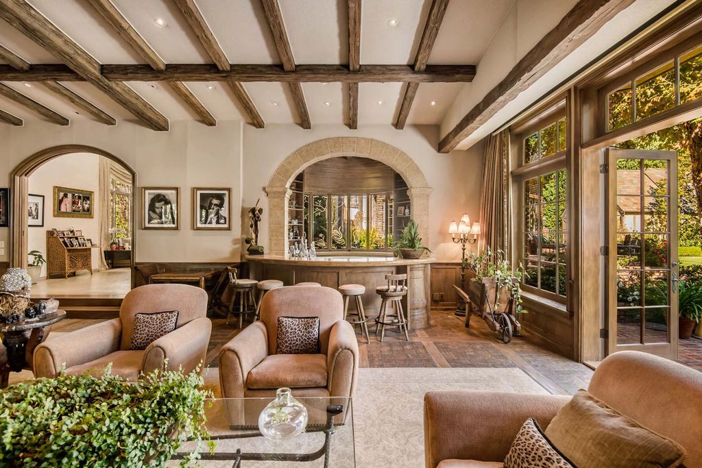 The Beverly Hills Estate, an exceptionally private Tudor-style residence surrounded by magnificent gardens, detailed with French country flair boasting classic design, majestic proportions, bucolic setting and unrivaled amenities is now available for sale. This home located at 1005 Woodland Dr, Beverly Hills, California